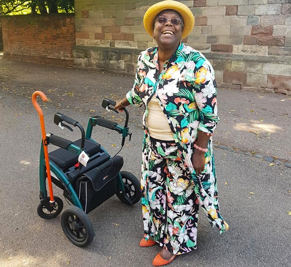 Femme conduisant un déambulateur Rollz Motion Performance avec un accessoire porte-canne