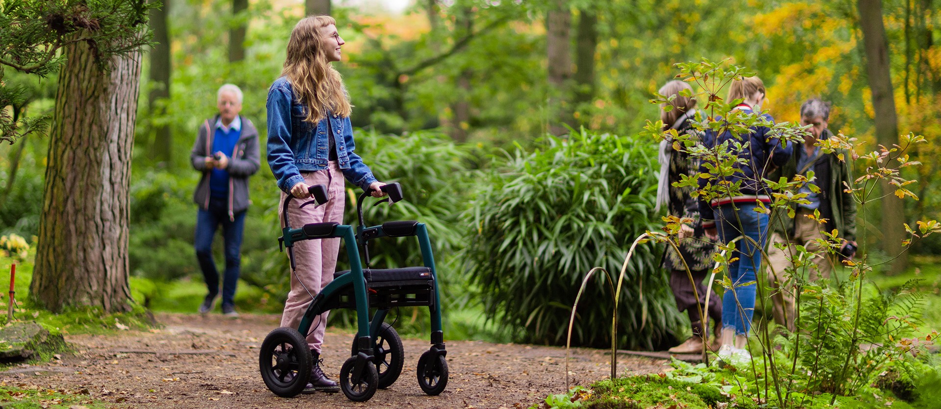 Young girl walking with a Rollz Motion Performance rollator with air tyres in a forest